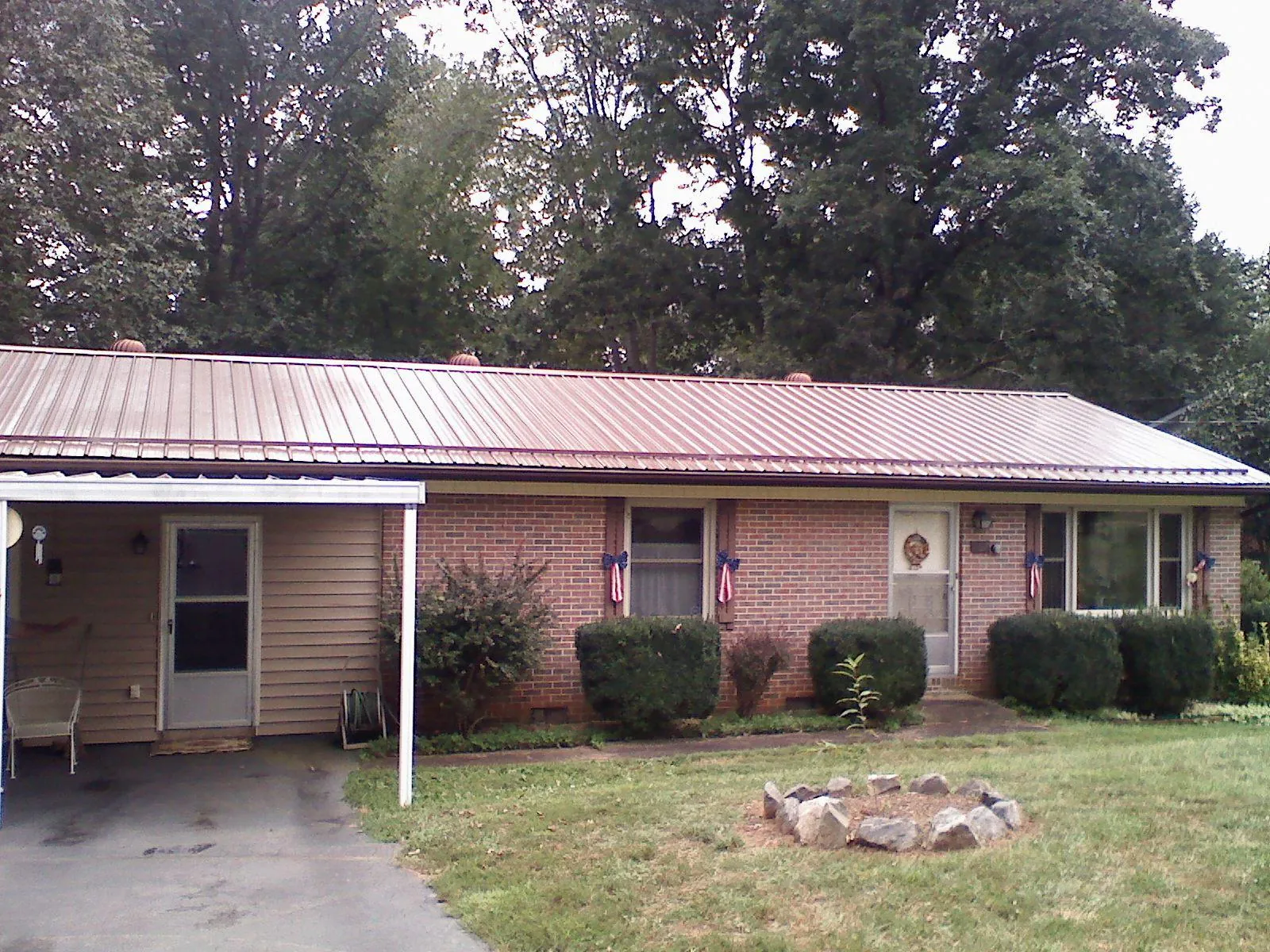 Bronze metal roof and carport on a brick ranch home — Roof Repair work by our crew in Liberty Hill