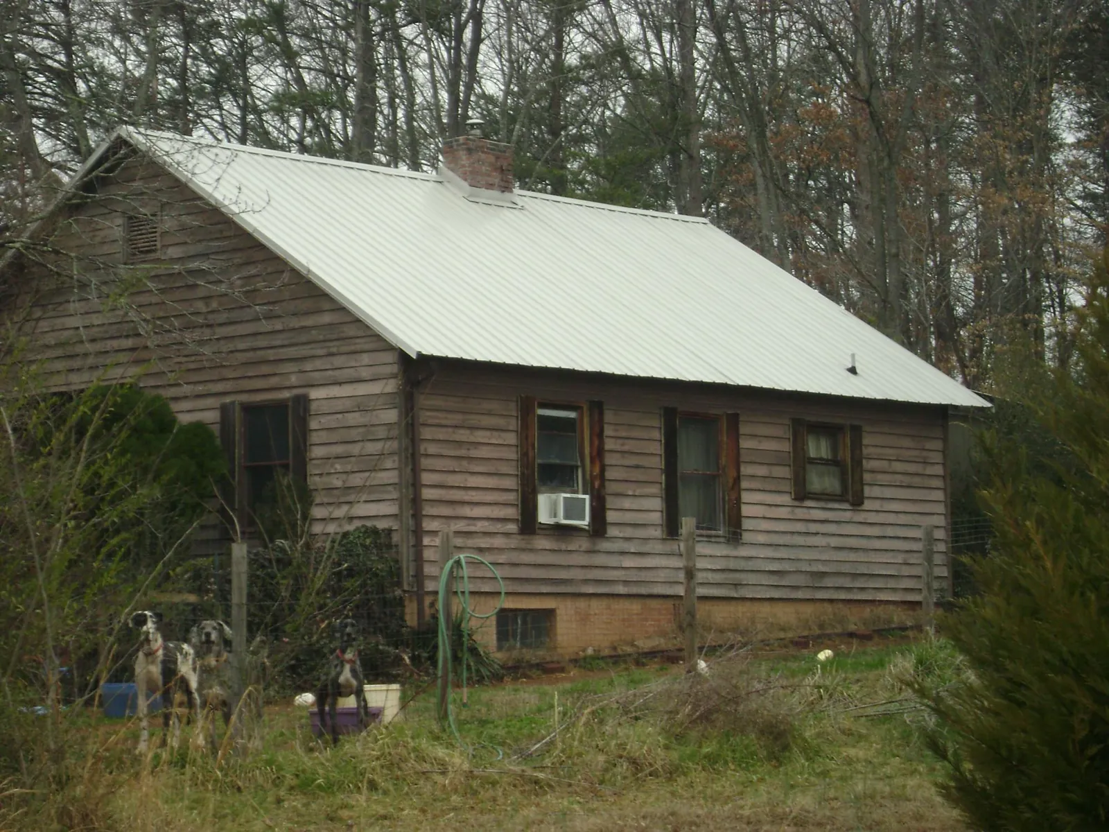 White metal roof on an old wood sided farmhouse, from a Metal Roof Installation job in Liberty Hill